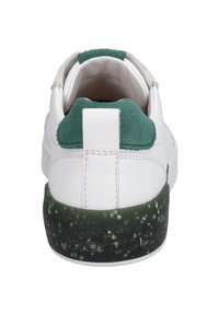 Białe sneakersy z zielonym zamszowym obszyciem pięty i nakrapianą zieloną podeszwą środkową. Posiadają górną część wykonaną z gładkiej skóry oraz pionową pętlę do zakupu na pięcie.