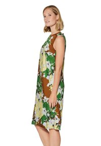 Blumenmusterkleid in Gelb, Grün und Braun. Sanfte Textur, ärmelloses Design und knielange Silhouette.