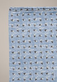 Tkanina tekstylna o jasnoniebieskim tle, z wzorem małych czarnych i złotych trójkątnych kształtów oraz teksturowaną powierzchnią.