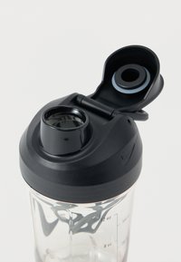 Διάφανο πλαστικό μπουκάλι shaker με μαύρο πλαστικό καπάκι και στόμιο. Διαθέτει ενδείξεις μέτρησης στην πλευρά και κλείσιμο με μεντεσέ.