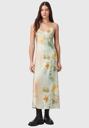 Kvetinové maxi šaty v jemnej zelenej gradácii s broskyňovými ružami a motýľmi; nastaviteľné tenké ramienka; hladká látka; doplnené čiernymi čižmami.