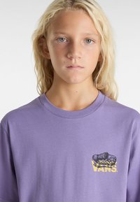 Fialové kotníkové tričko z bavlny s potiskem tenisky a textem "VANS" v žluté barvě. Kulatý výstřih, krátké rukávy, hladká textilie.