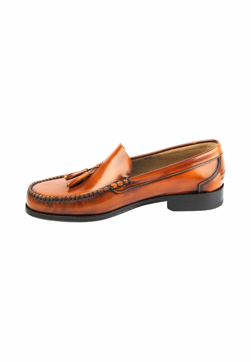 Mocasines de cuero marrón con adornos de borlas, que presentan un diseño cosido y una suela baja de goma negra. Textura elegante y suave en todo el zapato.