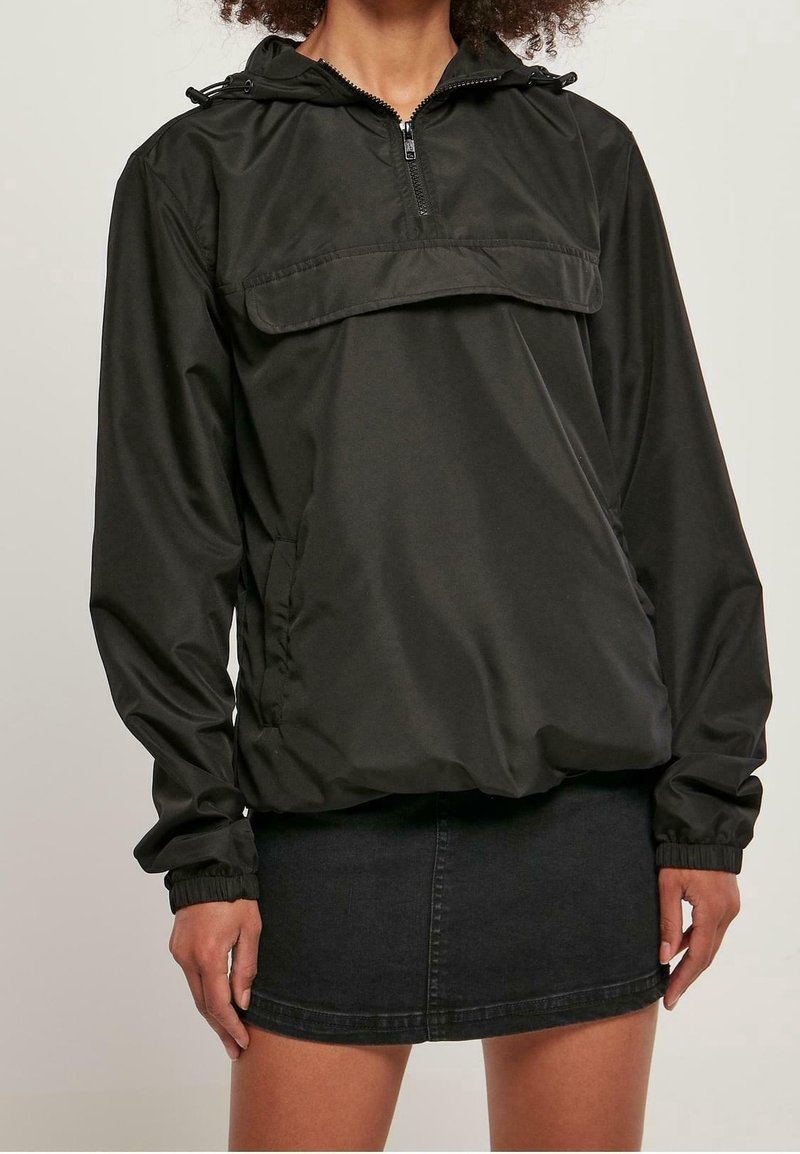 Svart lättviktspullov jacket med huva, halvdragkedja framtill, elastiska ärmslut och en framficka. Slät yta med avslappnad passform.