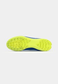 Sport shoe sole with a bright yellow rubber outsole featuring textured spikes for traction, attached to a blue upper material.