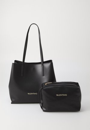 Sac fourre-tout en cuir noir avec deux longues poignées, présentant une texture lisse et un logo doré "VALENTINO". Accompagné d'une pochette assortie.