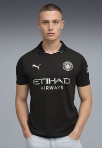 Svart fotbolls tröja med korta ärmar, med kollare, silverloggor och texten "ETIHAD AIRWAYS". Slät tyg med lätt lyster.