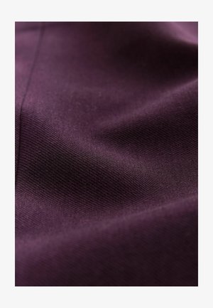 Lila Stoff mit glatter Textur und feiner Webart. Die Oberfläche weist subtile Variationen auf, die ein weiches, dezentes Erscheinungsbild erzeugen.