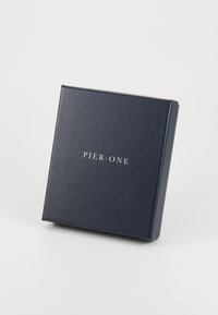 Boîte d'emballage noire avec une finition mate arborant le texte "PIER•ONE" en blanc, de forme carrée et aux bords nets.