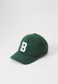 Mørkegrønn baseballcaps i myk stoff med en hvit bokstav "B" foran. Designet inkluderer en buet brem og ventilasjons hull.