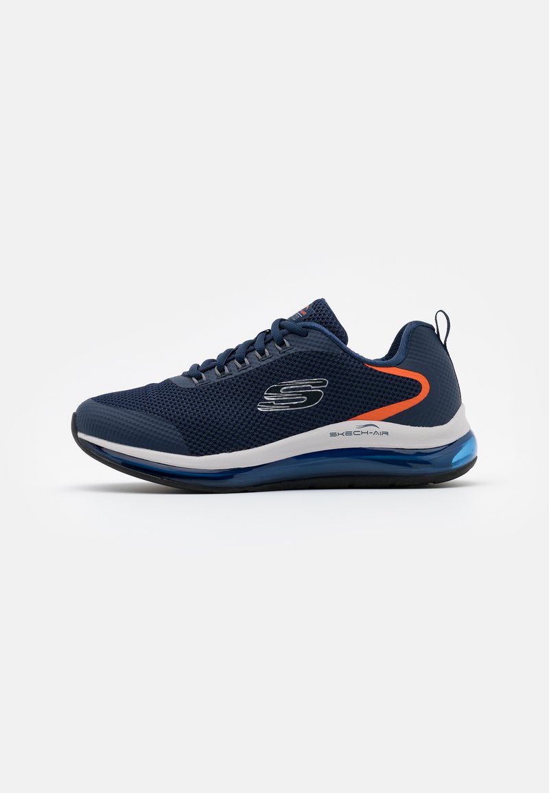 Baskets de sport en maille bleu marine avec semelle intermédiaire blanche, accents bleus et unité d'air arrière ronde. Caractéristiques : tige texturée et fermeture à lacets.