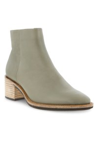 Botín de cuero verde con punta afilada, tacón de madera apilada y textura suave. Presenta un diseño sencillo y elegante sin herrajes visibles.