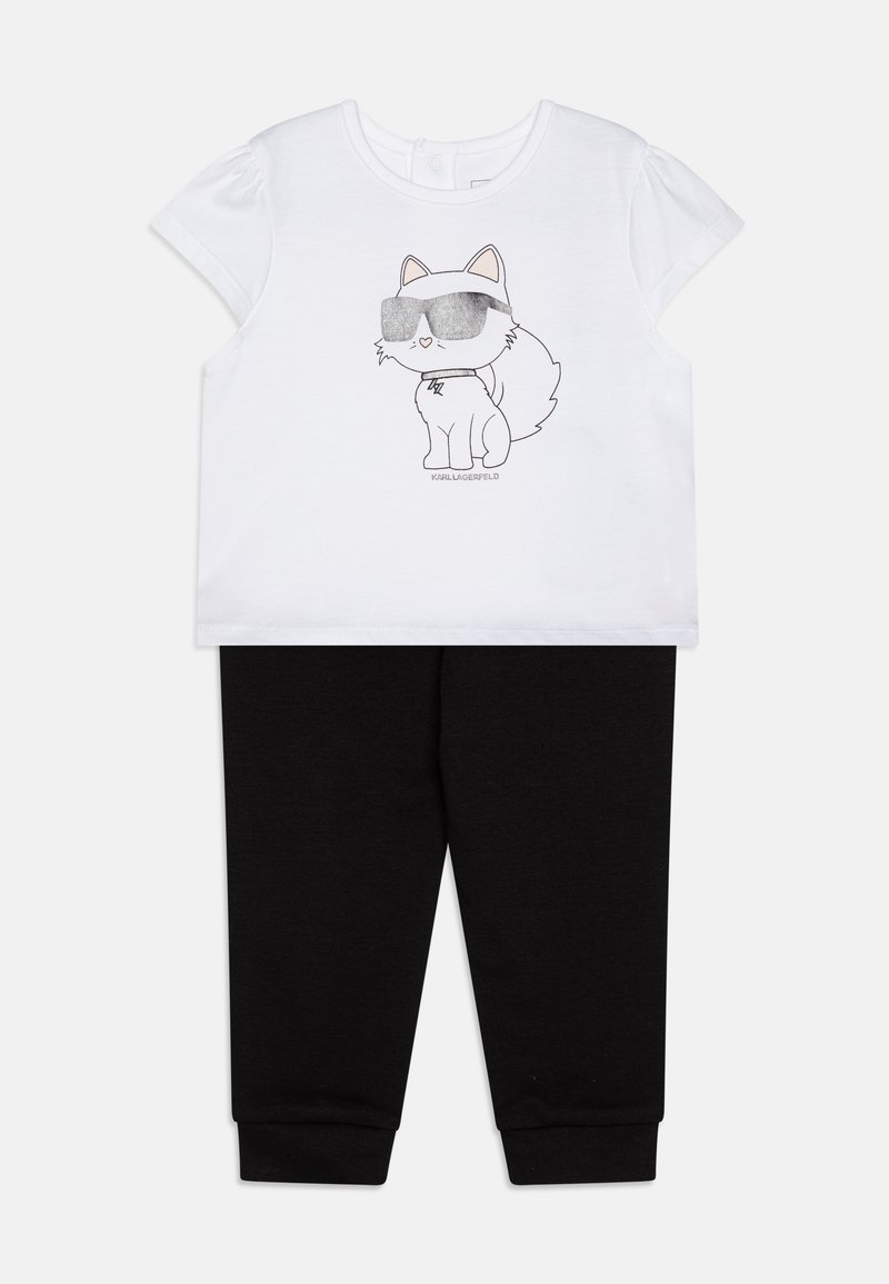T-shirt blanc à manches courtes avec un chien de cartoon portant des lunettes de soleil, associé à un pantalon noir avec taille élastique. Matière en coton, design décontracté.
