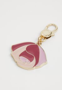 Trousse en or avec un design de rose en émail rose et mauve et un fermoir circulaire, sur fond blanc.