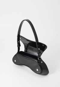 Black patent leather handbag with a curved design, featuring a structured handle and snap closure. Interior is lined and spacious.
