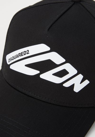 Casquette de baseball noire avec un texte graphique blanc "DSQUARED2" et un design abstrait. Fabriquée en tissu texturé avec une forme structurée.