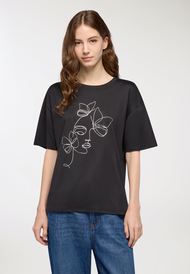 T-shirt nera a maniche corte con un design in linea bianca che rappresenta un volto e dei fiori. Materiale in cotone texturizzato, vestibilità rilassata e scollo a girocollo.