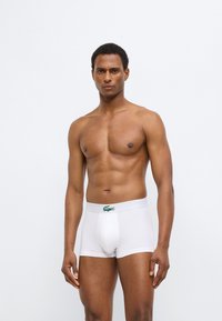 Λευκά βαμβακερά αντρικά εσώρουχα boxer με πράσινη ζώνη μέσης με λογότυπο, με εφαρμοστό σχεδιασμό και ομαλή υφή. Δεν φαίνεται άλλο ρούχο.