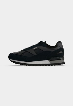 Baskets BOSS noires et grises avec dessus en mesh et cuir, fermeture à lacets et semelle extérieure noire texturée en caoutchouc, vue latérale sur fond blanc.