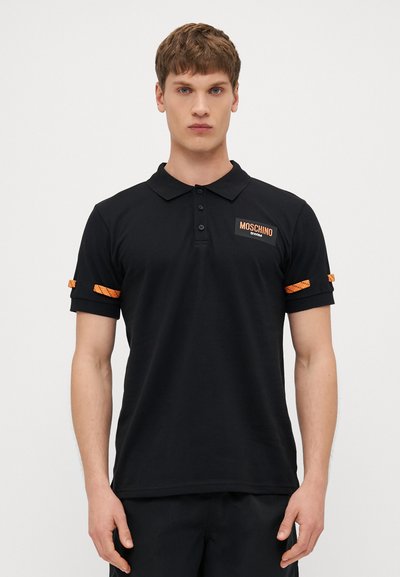 Polo shirt nera in cotone con colletto classico, caratterizzata da un logo Moschino Swim arancione e dettagli arancioni a fantasia sulle maniche.