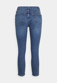 Jeans ajustados en denim azul oscuro con una textura suave, que cuentan con una cintura de altura media, diseño de cinco bolsillos y sutiles detalles de costura.