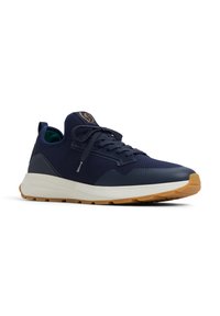 Zapatilla de malla navy con suela de goma, paneles en contraste de navy y gris, punta redonda, diseño con cordones y acento de logo en la lengüeta.