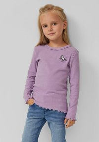 Paarse geribbelde langekదర్శhirt met golvende randen en een geborduurd paardenontwerp op de borst, gecombineerd met lichtblauwe jeans.