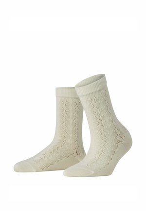 Par beige ankelstrømper med et delikat blonde-strikmønster og ribbede manchetter, vist mod en hvid baggrund.