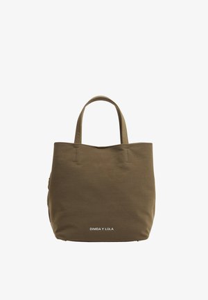 Tamsiai žalia pirkinių bolsa, pagaminta iš patvarios medžiagos, su dviem trumpais rankenoms, paprastu dizainu ir baltu logotipu priekyje, apačioje.