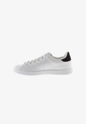 Weiße Sneakers aus glattem Leder mit durchbrochener Verarbeitung und einem strukturierten schwarzen Fersenakzent. Gummisohle und klassisches Schnürdesign.