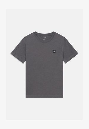 Pelēka kokvilnas t-krekls ar īsām piedurknēm, apaļu kakla izgriezumu un mazu melnbaltu "ck" logotipu uz kreisā krūšu rajona.