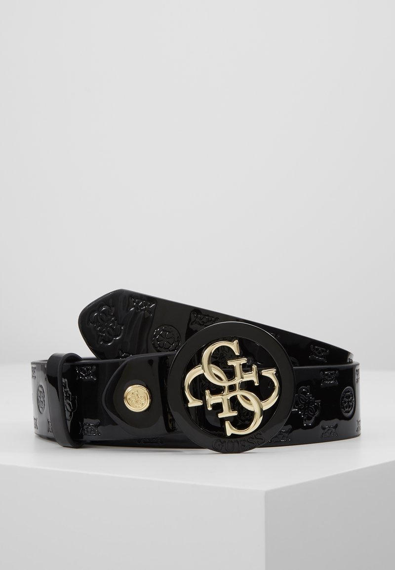 Ceinture en vinyle noir avec logos embossés et boucle ronde ornée des initiales entrelacées Guess en ton doré.