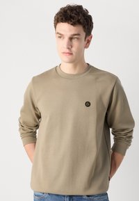 Khaki sweatshirt with ribbed crew neck and long sleeves, features a small black logo on the chest, made of soft cotton blend fabric.
