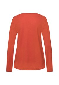 Camisa de manga larga en algodón de color óxido sólido, con un escote amplio y un corte recto sin adornos adicionales.