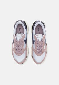 Zapatillas con una parte superior de malla blanca, suaves acentos de ante rosa, detalles en navy y una suela gruesa negra. Incluyen cordones y un collar acolchado.