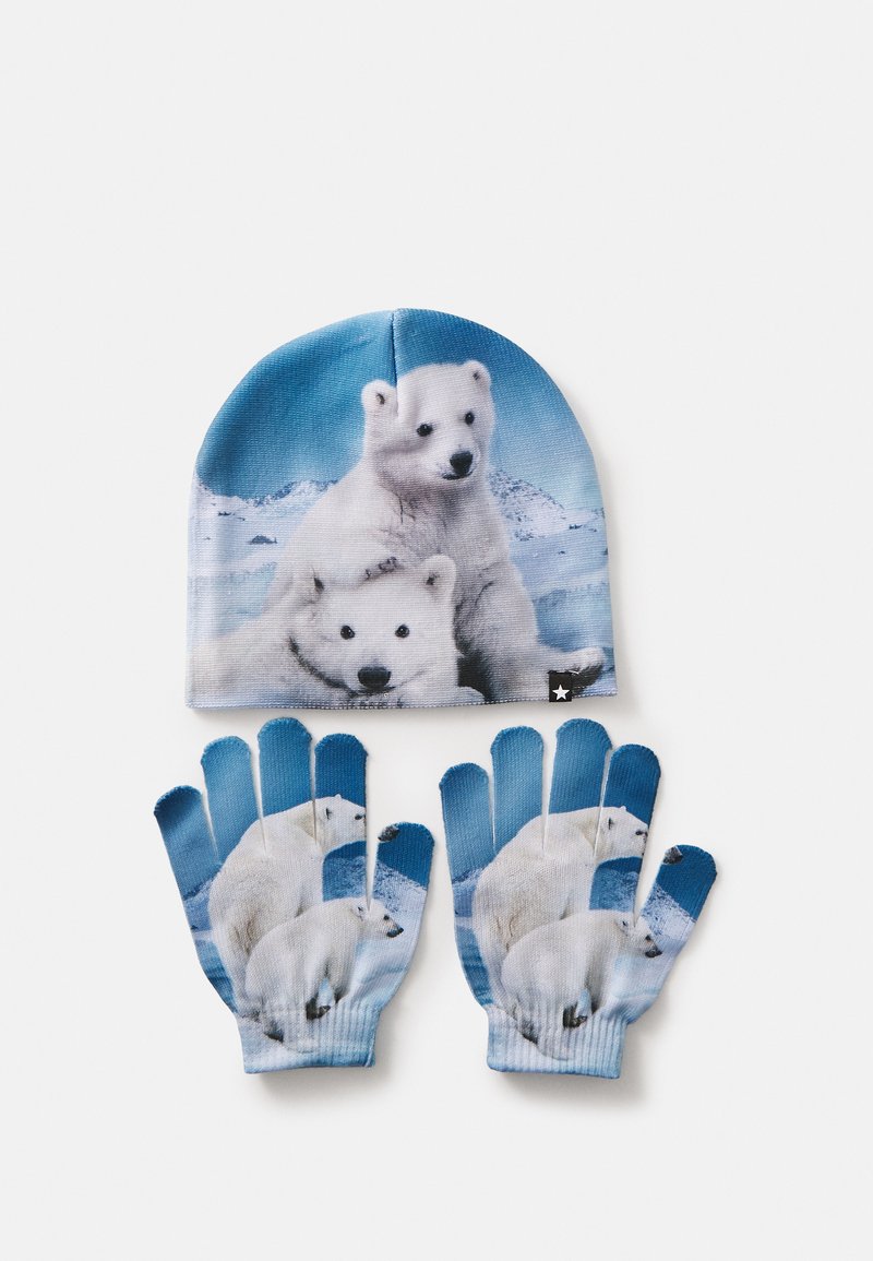 Blå mössa och matchande handskar med grafiska motiv av isbjörnar. Handskarna har öppna fingertoppar; mjukt, texturerat tyg. Vinteraccessoarset.