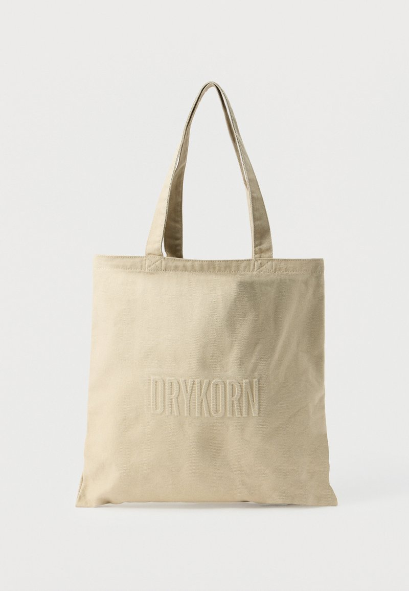 Sac cabas en toile beige avec doubles anses et logo "DRYKORN" embossé sur le devant.