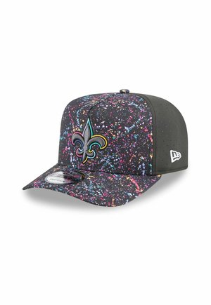 Casquette noire avec un motif éclaboussé coloré, featuring un logo en broderie de fleur de lys bien en évidence et une visière texturée noire uniforme.