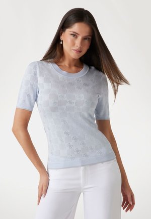 Lichtblauwe sweater met korte mouwen, voorzien van een gestructureerd ruitpatroon, ronde halslijn en een gladde afwerking. Gestyleerd met witte broek.
