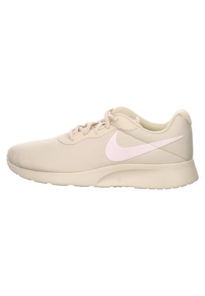 Zapatillas deportivas beige con un upper de tela texturizada, un logo de swoosh de Nike en suave color rosa, cordones planos y una suela de goma acolchada.