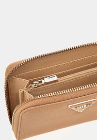 Portafoglio beige in materiale sintetico texturizzato, con cerniera dorata, più scomparti per carte e una tasca per monete con cerniera.