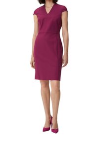 Figurbetontes Kleid mit kurzen Ärmeln in tiefem Magenta, V-Ausschnitt, glatter Textur und knielangem Schnitt, kombiniert mit passenden High Heels.
