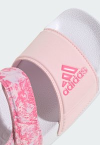 Chancla Adidas con una tira de patrón de mármol rosa, una banda rosa suave con logotipo en relieve y una plantilla blanca texturizada.