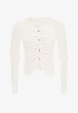 Witte geribbelde cardigan met een aansluitende pasvorm, geplooide details aan de voorkant en drie gouden knopen voor sluiting. Lange mouwen met gepofte schouders.
