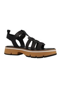 Sandalia de cuero negro con múltiples correas, suela de plataforma gruesa en tonos marrón y blanco, y detalle de hebilla. Suela texturizada con ranuras para tracción.