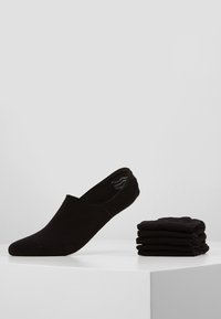 Calzini neri invisibili realizzati in morbido tessuto, con una superficie liscia e un design minimalista. Cinque paia impilati ordinatamente accanto a un calzino.