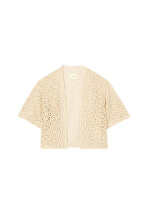 Cardigan beige en dentelle à ouverture frontale avec des motifs floraux circulaires et des manches courtes larges, léger et semi-transparent.