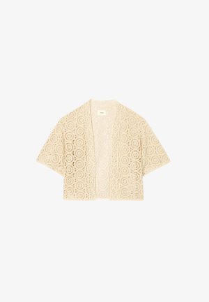 Cardigan beige en dentelle à ouverture frontale avec des motifs floraux circulaires et des manches courtes larges, léger et semi-transparent.