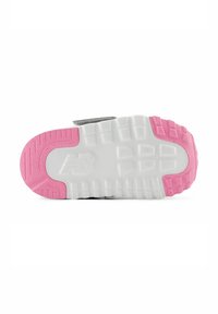 Suola di sneaker grigia e bianca con accenti in gomma rosa. Parte inferiore testurizzata con scanalature per la presa e un logo vicino al tallone.