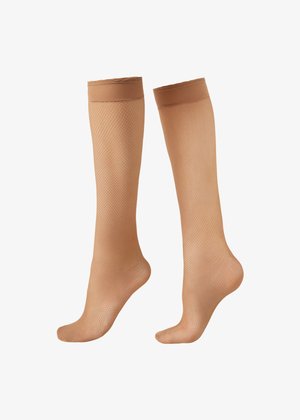 Paire de bas résille beige montant aux genoux avec bandes élastiques renforcées en haut sur fond blanc.